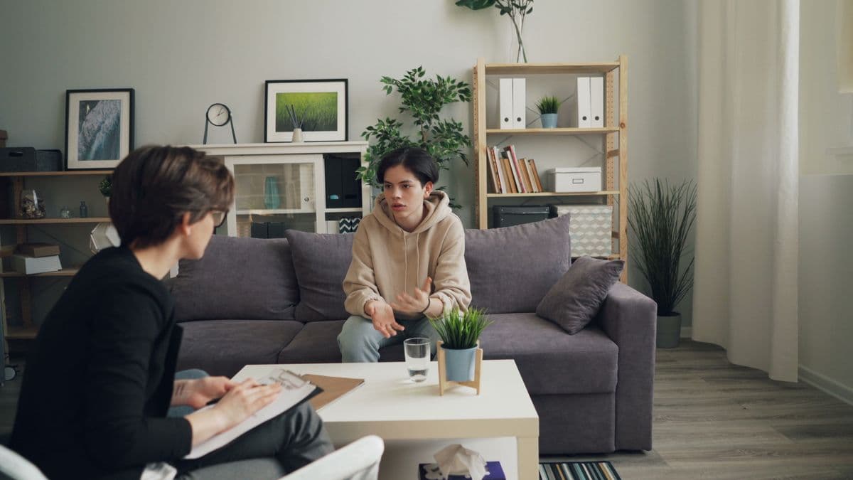 A therapist talking with a teenage client in a counseling session